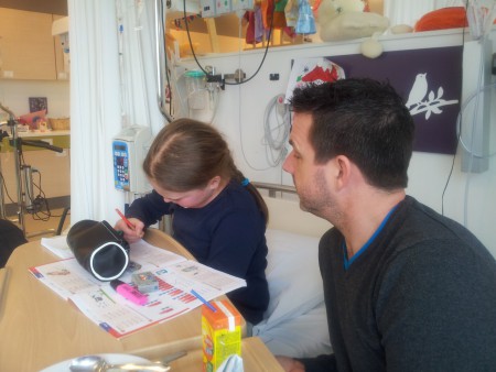 Papa helpt met huiswerk in het ziekenhuis